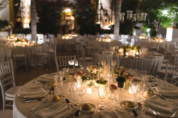 Luxury wedding reception setup with elegant floral centerpieces and sophisticated lighting design.