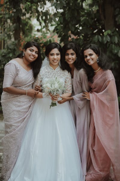 Bride wearing a stunning traditional dress with intricate embroidery, standing in a lush garden setting for her multicultural wedding.